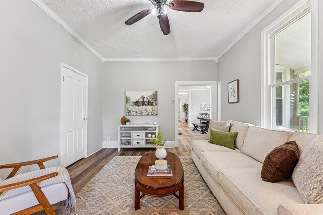 264 W High St, Mount Gilead, OH 43338 - living room featuring wood finished floors, a ceiling fan, a textured ceiling, and crown molding