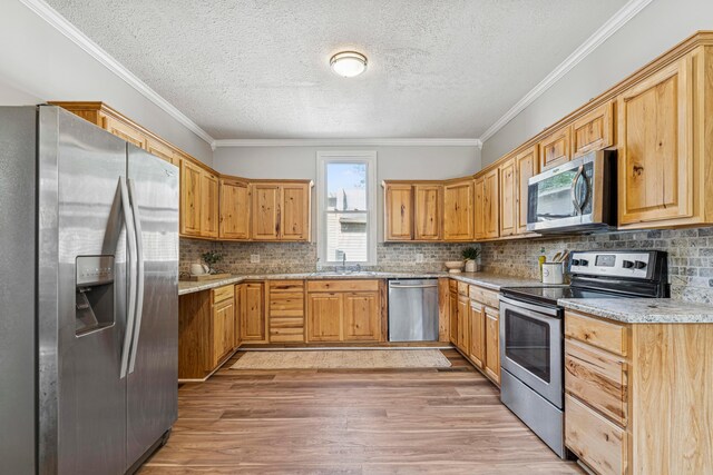 264 W High St, Mount Gilead, OH 43338 - kitchen with stainless steel appliances, light wood finished floors, a textured ceiling, crown molding, and backsplash