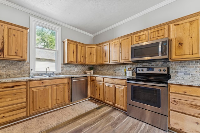 264 W High St, Mount Gilead, OH 43338 - kitchen with stainless steel appliances, light wood-style floors, a textured ceiling, backsplash, and crown molding