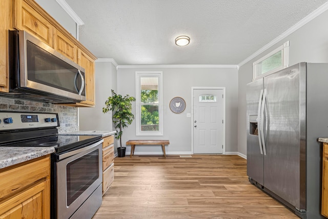264 W High St, Mount Gilead, OH 43338 - kitchen featuring stainless steel appliances, crown molding, light wood-style floors, backsplash, and light countertops
