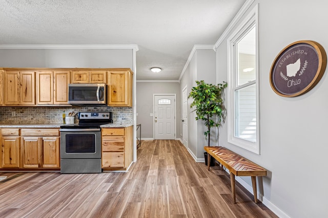 264 W High St, Mount Gilead, OH 43338 - kitchen with stainless steel appliances, tasteful backsplash, light wood-style floors, ornamental molding, and light countertops