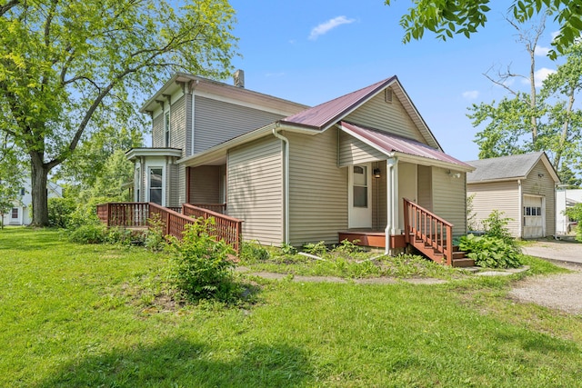 264 W High St, Mount Gilead, OH 43338 - view of front of house with a chimney, an outdoor structure, a front lawn, a metal roof, and a deck