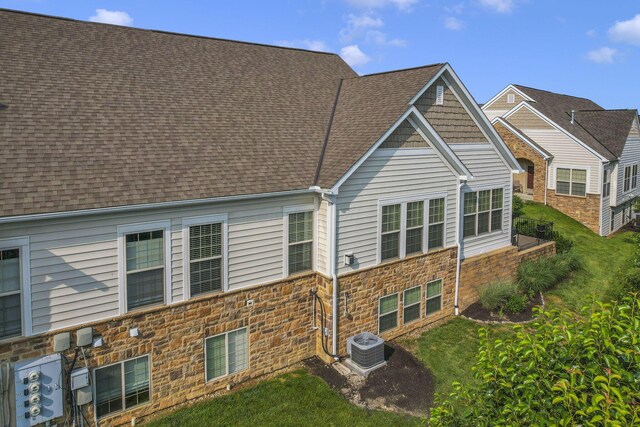 5685 Slater Rdg, Hilliard, OH 43026 - back of property featuring stone siding, roof with shingles, and a yard