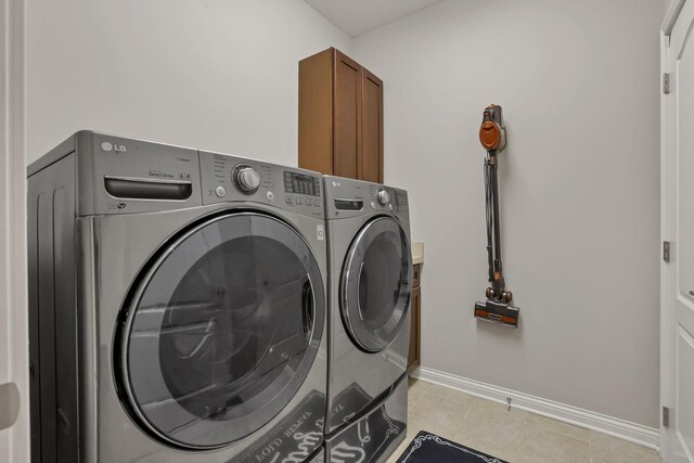 5685 Slater Rdg, Hilliard, OH 43026 - washroom with washer and dryer, light tile patterned floors, and cabinet space