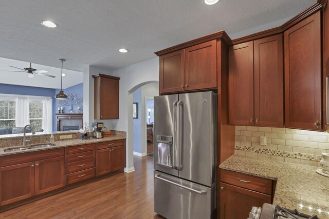 5685 Slater Rdg, Hilliard, OH 43026 - kitchen with stainless steel fridge, arched walkways, ceiling fan, tasteful backsplash, and light stone countertops