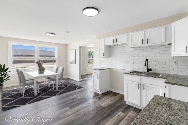 2045 Joyce Ave, Columbus, OH 43219 - kitchen featuring dark stone countertops, backsplash, dark wood-style floors, white cabinetry, and healthy amount of natural light