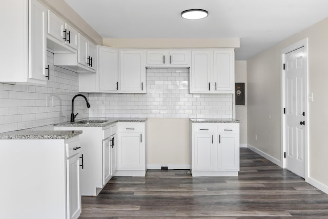 2045 Joyce Ave, Columbus, OH 43219 - kitchen featuring light stone counters, decorative backsplash, dark wood-type flooring, and white cabinets