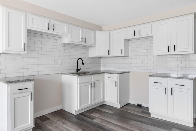 2045 Joyce Ave, Columbus, OH 43219 - kitchen with light stone countertops, tasteful backsplash, dark wood finished floors, and white cabinets