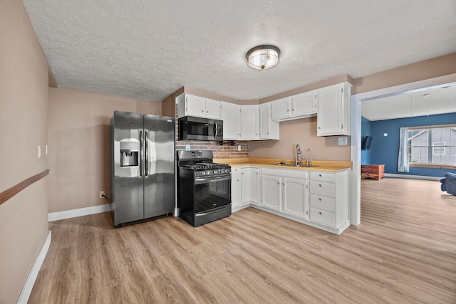 972 Weiant Ave, Newark, OH 43055 - kitchen featuring stainless steel appliances, light wood finished floors, white cabinetry, light countertops, and a textured ceiling