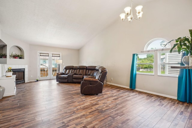 921 Harbinger Cir E, Columbus, OH 43213 - living room featuring a chandelier, wood finished floors, a tile fireplace, and high vaulted ceiling