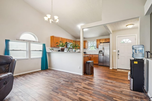 921 Harbinger Cir E, Columbus, OH 43213 - kitchen featuring stainless steel refrigerator with ice dispenser, open floor plan, brown cabinets, tasteful backsplash, and vaulted ceiling