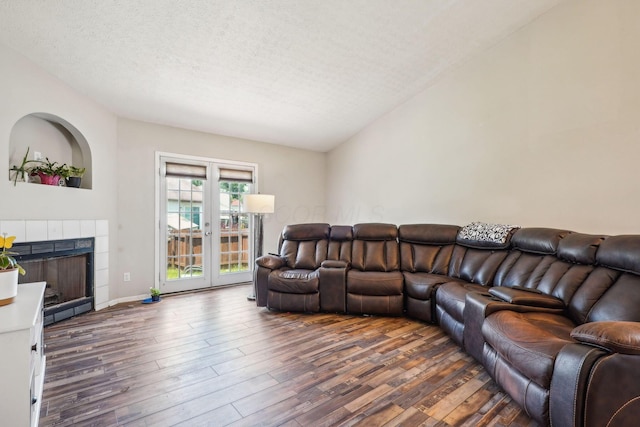 921 Harbinger Cir E, Columbus, OH 43213 - living room with wood finished floors, a textured ceiling, and a tiled fireplace