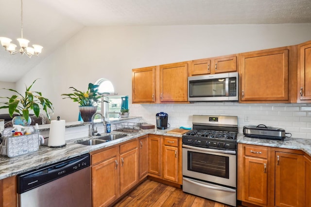 921 Harbinger Cir E, Columbus, OH 43213 - kitchen with appliances with stainless steel finishes, dark wood-type flooring, backsplash, a chandelier, and light stone countertops