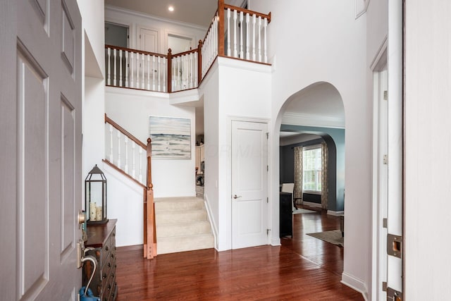 7212 New Albany Links Dr, New Albany, OH 43054 - entrance foyer featuring stairway, wood finished floors, arched walkways, ornamental molding, and a towering ceiling