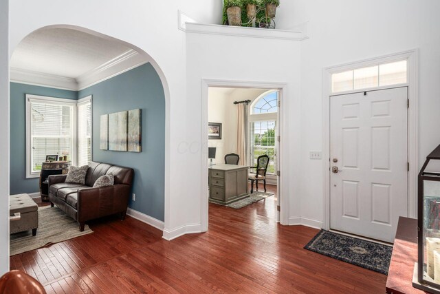 7212 New Albany Links Dr, New Albany, OH 43054 - foyer entrance with arched walkways, dark wood-style floors, and ornamental molding