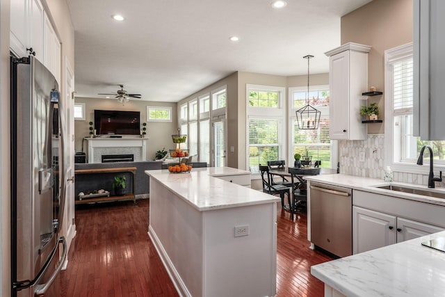 7212 New Albany Links Dr, New Albany, OH 43054 - kitchen featuring stainless steel appliances, open floor plan, ceiling fan, a fireplace, and recessed lighting