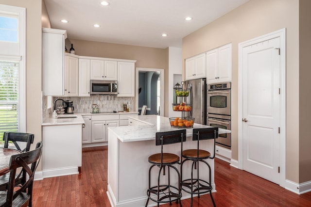 7212 New Albany Links Dr, New Albany, OH 43054 - kitchen featuring stainless steel appliances, dark wood-style floors, a center island, backsplash, and recessed lighting