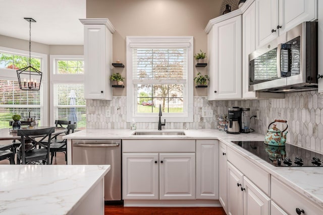 7212 New Albany Links Dr, New Albany, OH 43054 - kitchen with appliances with stainless steel finishes, white cabinets, tasteful backsplash, and a chandelier