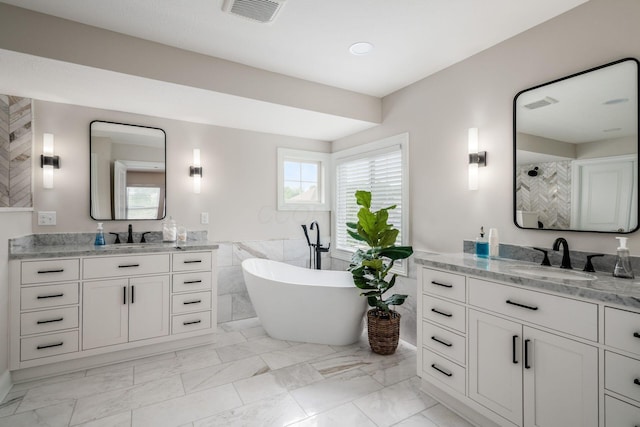 7212 New Albany Links Dr, New Albany, OH 43054 - full bath featuring two vanities, a soaking tub, marble look tiles, tile walls, and wainscoting