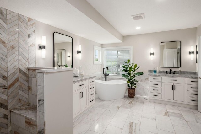 7212 New Albany Links Dr, New Albany, OH 43054 - bathroom featuring tile walls, a soaking tub, two vanities, walk in shower, and marble finish flooring