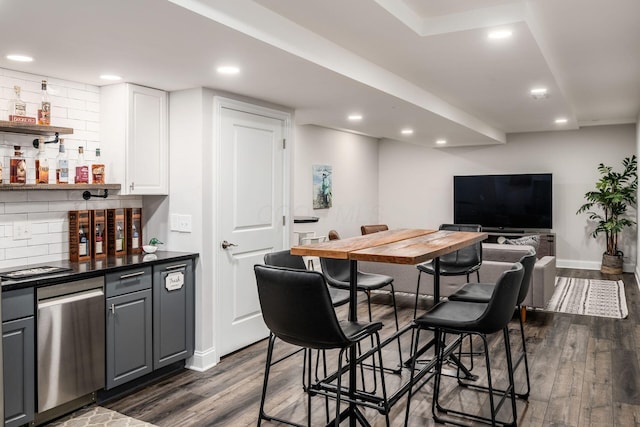 7212 New Albany Links Dr, New Albany, OH 43054 - indoor dry bar featuring dark wood finished floors, stainless steel dishwasher, decorative backsplash, and recessed lighting