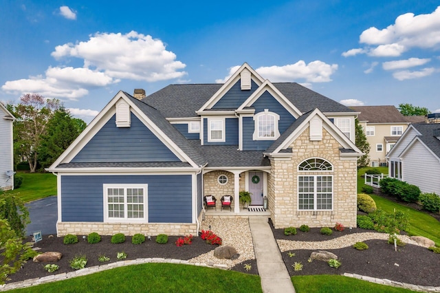 7212 New Albany Links Dr, New Albany, OH 43054 - view of front of property featuring stone siding, a porch, a shingled roof, and a chimney