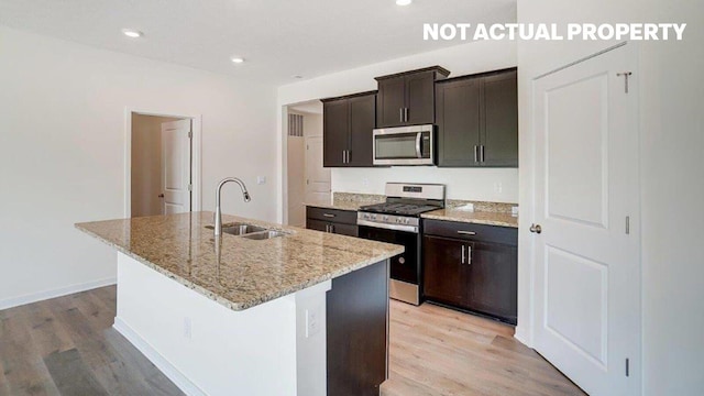 183 Badger Pass, Newark, OH 43055 - kitchen with appliances with stainless steel finishes, light wood finished floors, an island with sink, light stone counters, and recessed lighting