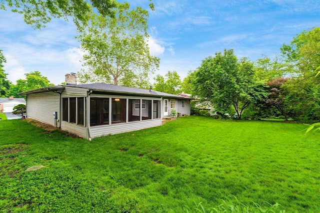 893 Singing Hills Ln, Columbus, OH 43235 - rear view of property with a chimney, a sunroom, and a lawn