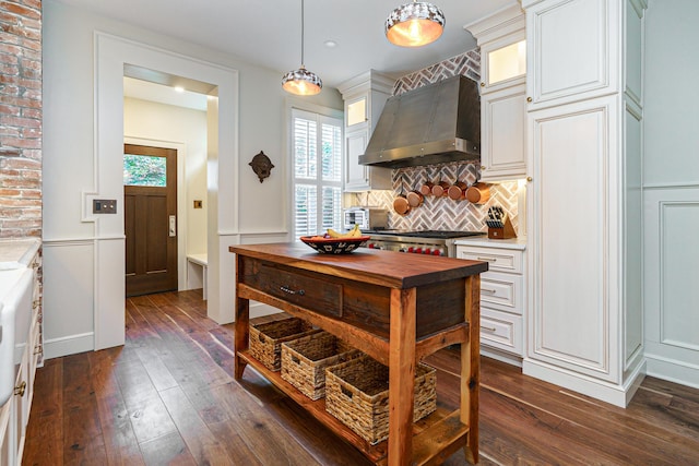 33 E Frankfort St, Columbus, OH 43206 - kitchen featuring wall chimney exhaust hood, dark wood finished floors, glass insert cabinets, tasteful backsplash, and a decorative wall