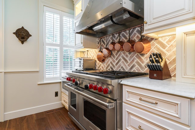 33 E Frankfort St, Columbus, OH 43206 - kitchen with double oven range, under cabinet range hood, decorative backsplash, dark wood-style floors, and cream cabinets