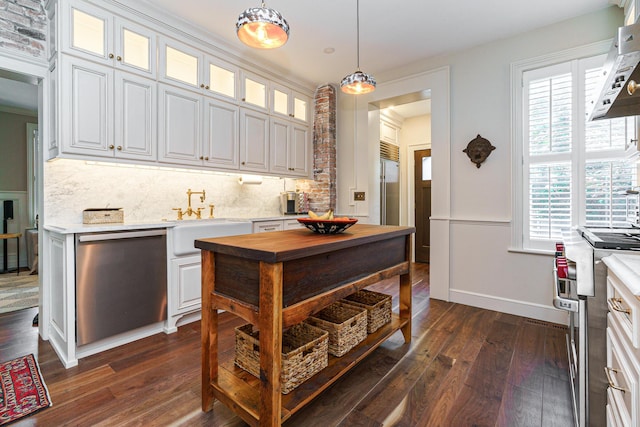 33 E Frankfort St, Columbus, OH 43206 - kitchen with premium appliances, range hood, decorative backsplash, dark wood finished floors, and white cabinetry