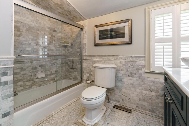 33 E Frankfort St, Columbus, OH 43206 - bathroom with tile walls, combined bath / shower with glass door, vanity, and a wainscoted wall