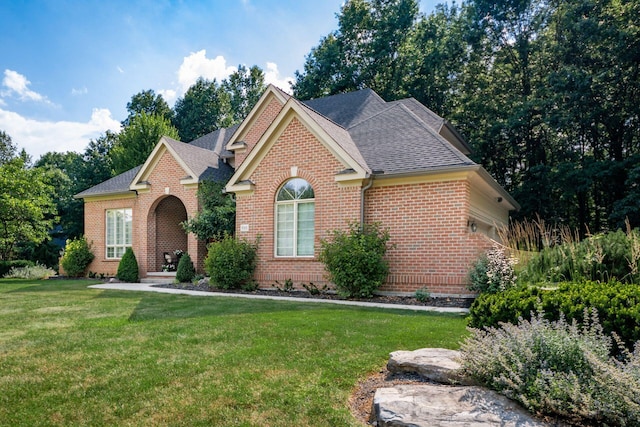 8918 Filiz Ln, Powell, OH 43065 - view of front facade featuring brick siding, a front yard, and a shingled roof
