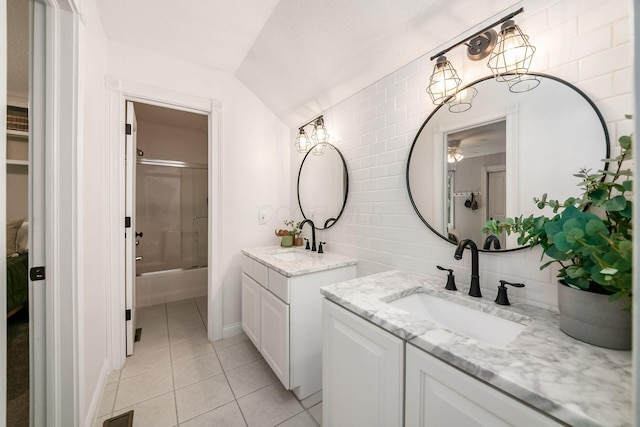 8918 Filiz Ln, Powell, OH 43065 - bathroom featuring two vanities, tile patterned floors, enclosed tub / shower combo, lofted ceiling, and a ceiling fan