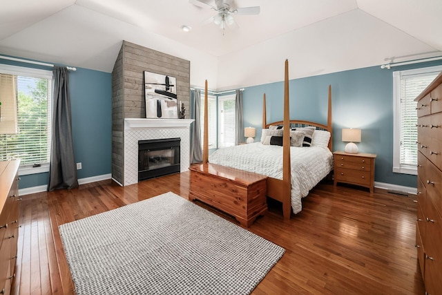 8918 Filiz Ln, Powell, OH 43065 - bedroom featuring lofted ceiling, hardwood / wood-style floors, a tiled fireplace, and a ceiling fan
