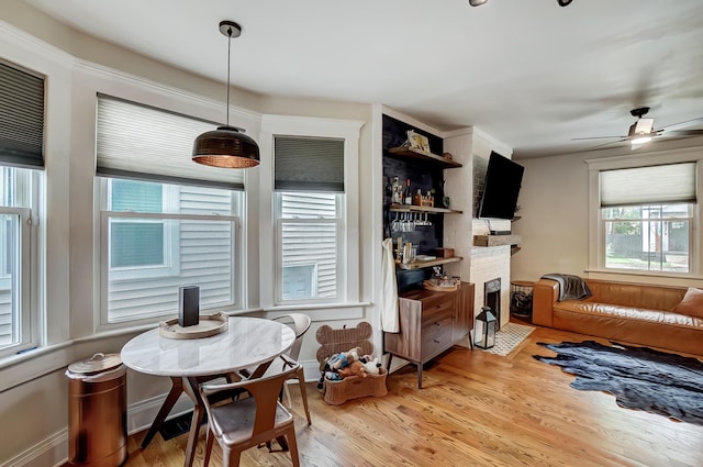 573 E Mithoff St, Columbus, OH 43206 - dining space with a fireplace with flush hearth, wood finished floors, and a ceiling fan