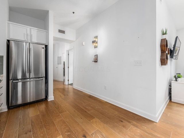 825 N 4th St Unit 215, Columbus, OH 43215 - kitchen with freestanding refrigerator, wood finished floors, and white cabinets