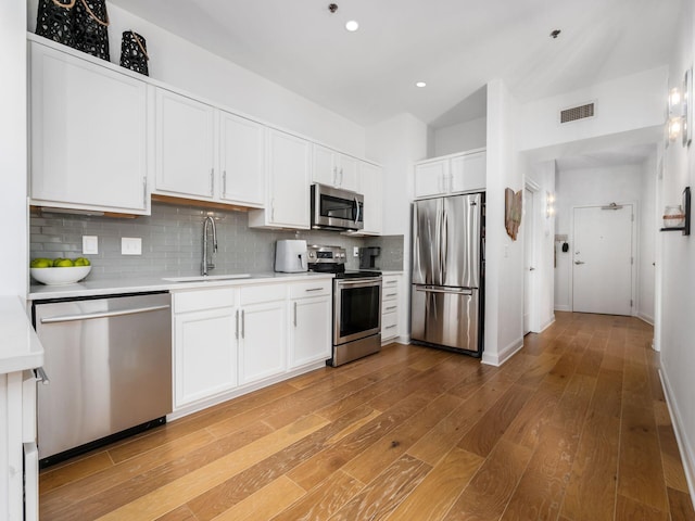 825 N 4th St Unit 215, Columbus, OH 43215 - kitchen with appliances with stainless steel finishes, light countertops, decorative backsplash, white cabinets, and recessed lighting