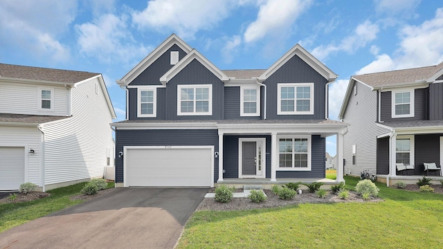 8145 Rhoderick Cir, Reynoldsburg, OH 43068 - view of front of property with covered porch, board and batten siding, driveway, an attached garage, and a front lawn