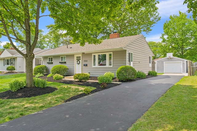 2554 Nottingham Rd, Upper Arlington, OH 43221 - view of front of property with an outbuilding, a chimney, a garage, asphalt driveway, and a front lawn