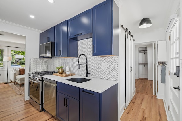 2554 Nottingham Rd, Upper Arlington, OH 43221 - kitchen with blue cabinets, appliances with stainless steel finishes, ornamental molding, light countertops, and a barn door