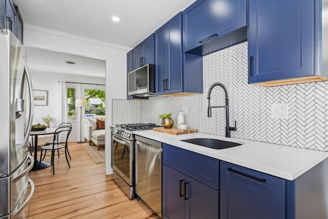 2554 Nottingham Rd, Upper Arlington, OH 43221 - kitchen featuring appliances with stainless steel finishes, blue cabinetry, light countertops, tasteful backsplash, and light wood-type flooring