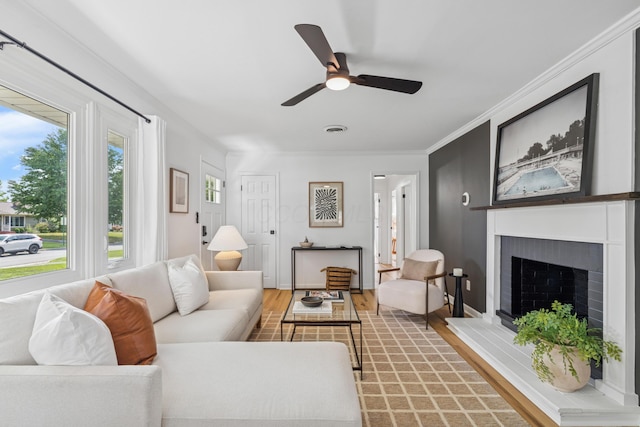 2554 Nottingham Rd, Upper Arlington, OH 43221 - living room featuring light wood-type flooring, ceiling fan, a fireplace with raised hearth, and ornamental molding