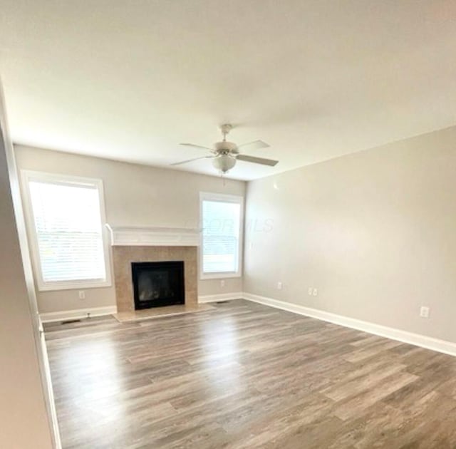 332 Bottecchia Blvd, Johnstown, OH 43031 - unfurnished living room featuring wood finished floors, a tile fireplace, and a ceiling fan