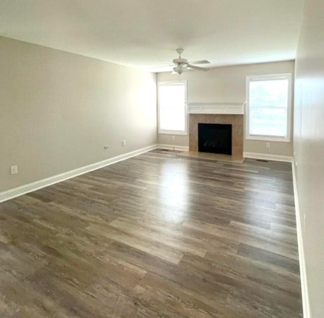 332 Bottecchia Blvd, Johnstown, OH 43031 - unfurnished living room featuring ceiling fan, healthy amount of natural light, a fireplace with flush hearth, and dark wood-style floors