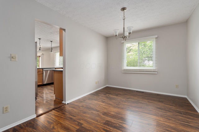 2268 Worthingwoods Blvd, Powell, OH 43065 - spare room featuring plenty of natural light, a chandelier, dark wood-type flooring, and a textured ceiling