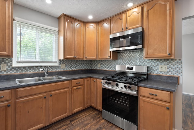 2268 Worthingwoods Blvd, Powell, OH 43065 - kitchen with stainless steel appliances, dark countertops, dark wood-type flooring, backsplash, and a textured ceiling