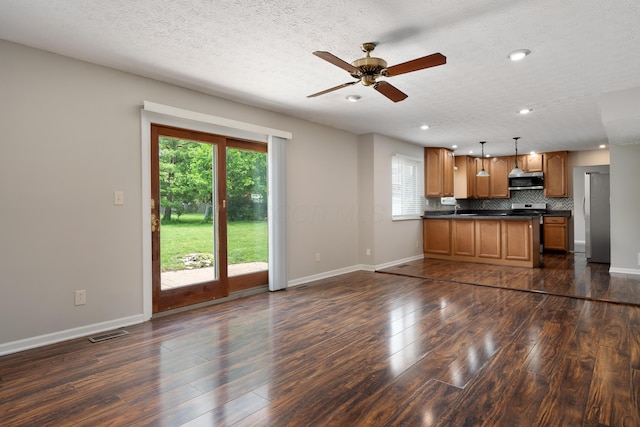 2268 Worthingwoods Blvd, Powell, OH 43065 - unfurnished living room with plenty of natural light, dark wood-style floors, ceiling fan, recessed lighting, and a textured ceiling