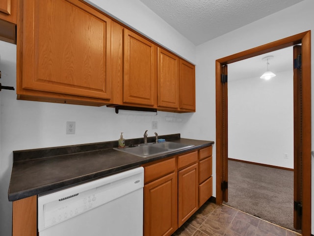 865 Westbury Ln S Unit 12B, Columbus, OH 43228 - kitchen featuring white dishwasher, dark countertops, brown cabinetry, dark colored carpet, and a textured ceiling