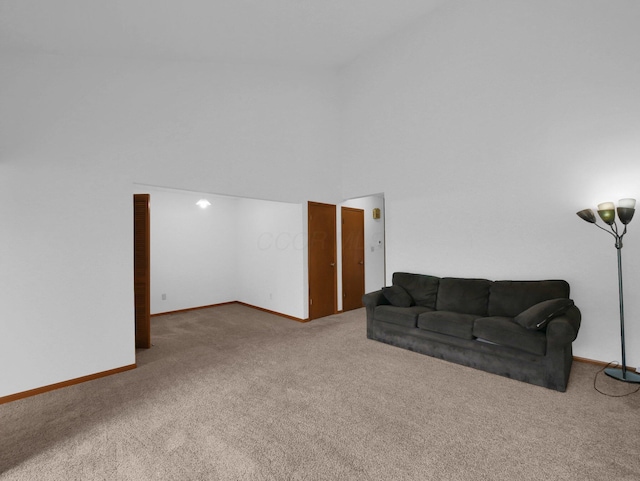 865 Westbury Ln S Unit 12B, Columbus, OH 43228 - carpeted living room featuring baseboards and a high ceiling